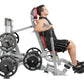 Man using gray and red Hoist abdominal exercise machine with weight plates, demonstrating seated crunch position