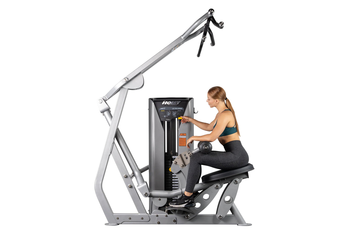 Woman using silver and black Hoist lat pulldown machine with overhead pulley and weight stack on white background