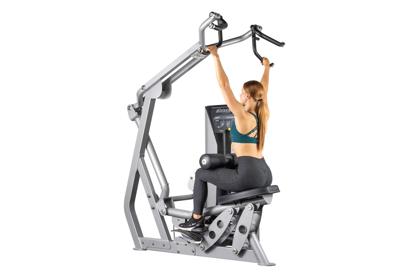 Woman using silver Hoist ROC-IT lat pulldown machine with black handles and digital display on white background