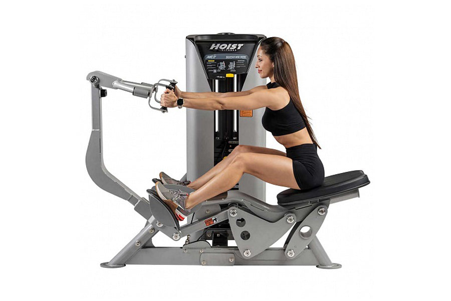 Hoist ROC-IT Seated Mid Row Machine with gray frame and black seat, woman in black workout attire using rowing handles in sea