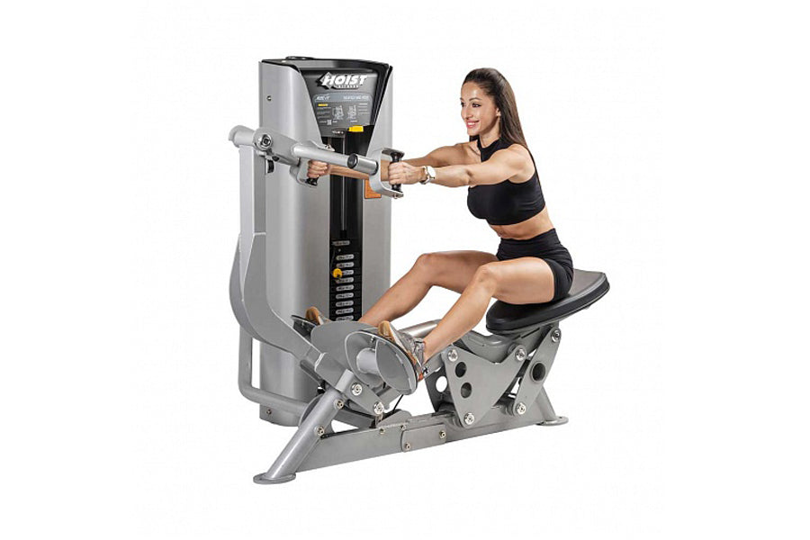 Woman using silver and black Hoist ROC-IT seated mid row machine with digital control panel, demonstrating proper form on whi