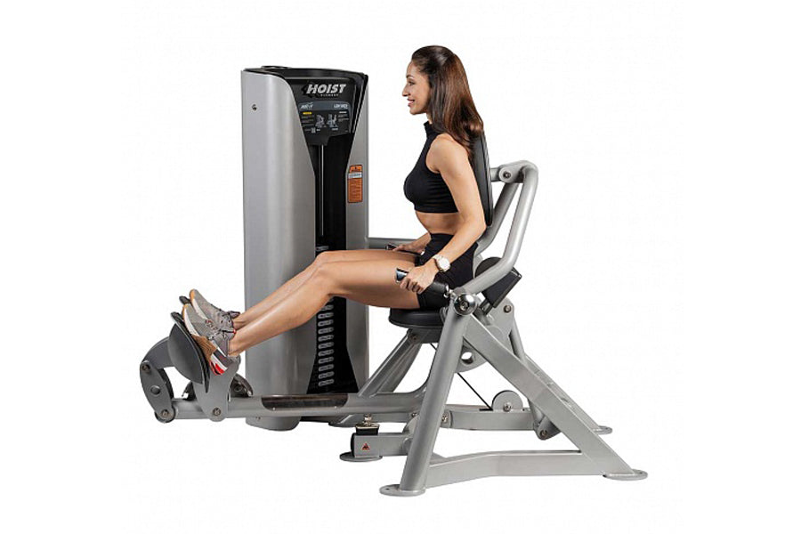 Woman using Hoist ROC-IT lower back machine with silver frame and black control panel, seated position on white background