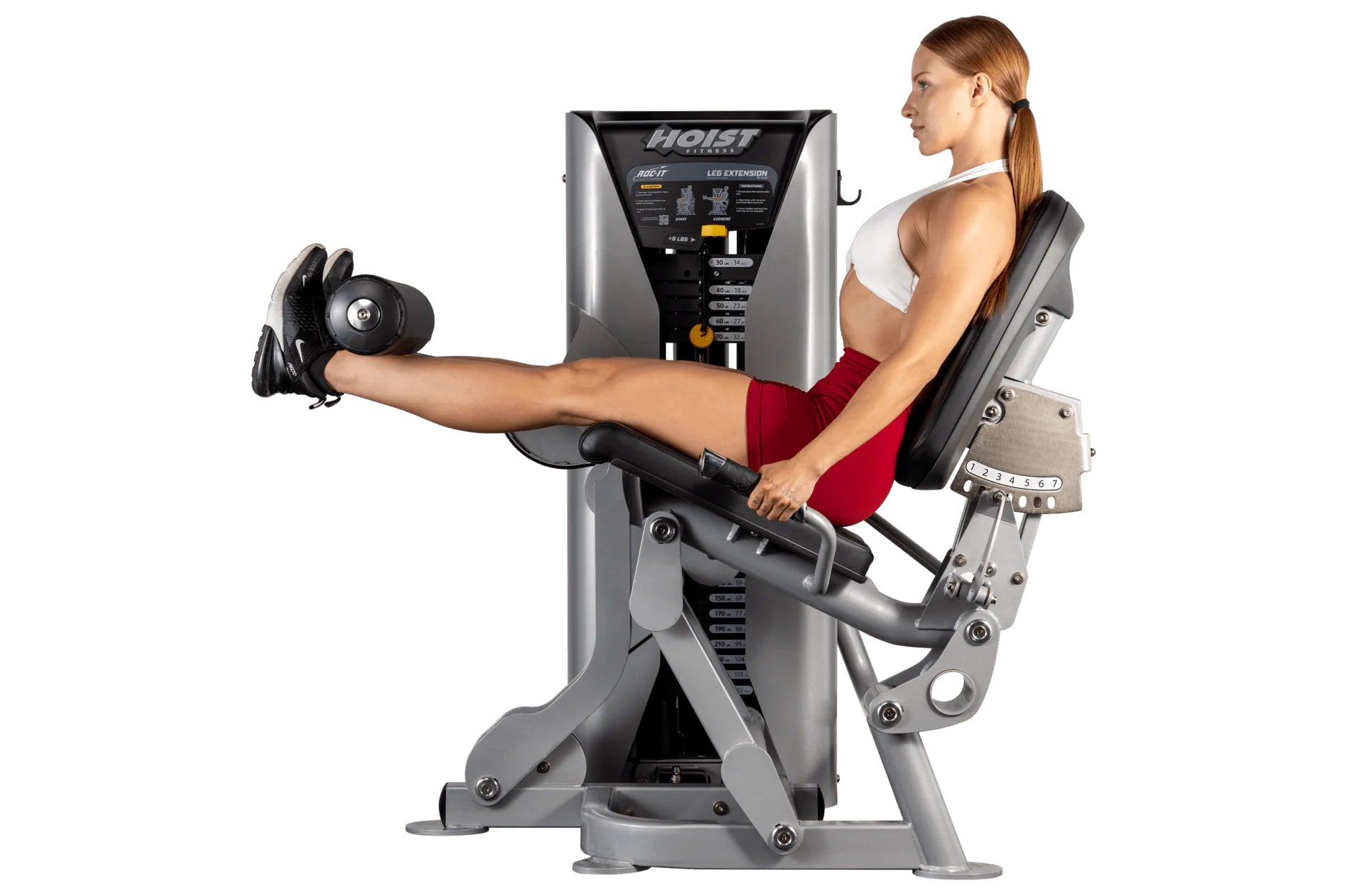 Woman using Hoist ROC-IT leg extension machine with silver and black frame, demonstrating seated leg exercise position