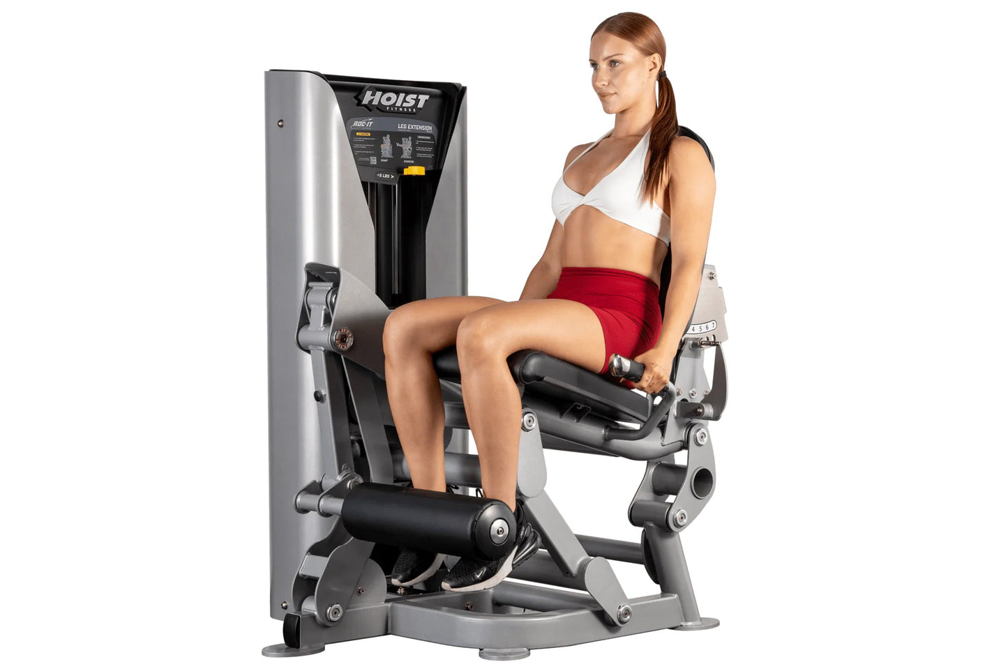 Woman using Hoist ROC-IT leg extension machine with silver and black frame, demonstrating seated leg exercise position