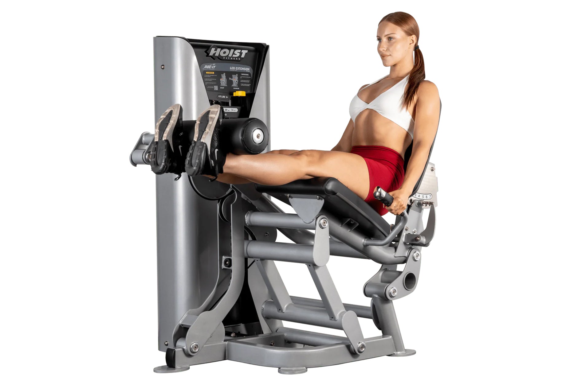 Woman using silver and black Hoist leg extension machine with adjustable footrest and control panel, on white background