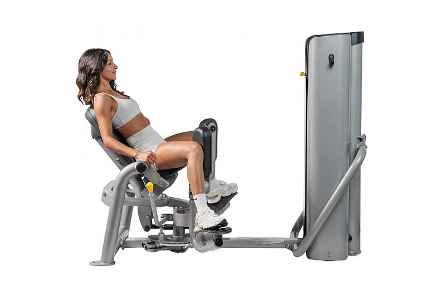 Gray leg press machine with model demonstrating seated position, isolating inner thigh muscles