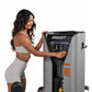 Woman in gray sports bra and shorts using Hoist ROC-IT Outer Thigh Machine, silver and black leg press equipment with control