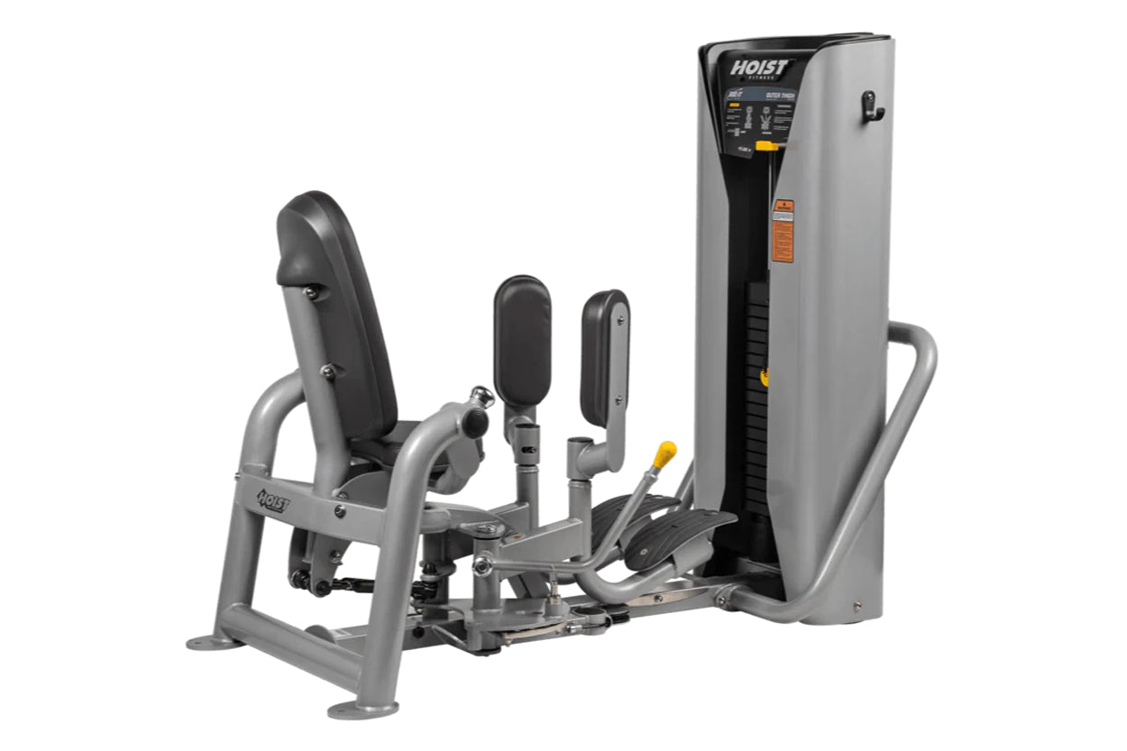 Hoist ROC-IT outer thigh machine with gray frame, black padded seat and leg press, control panel with orange accents on tall 