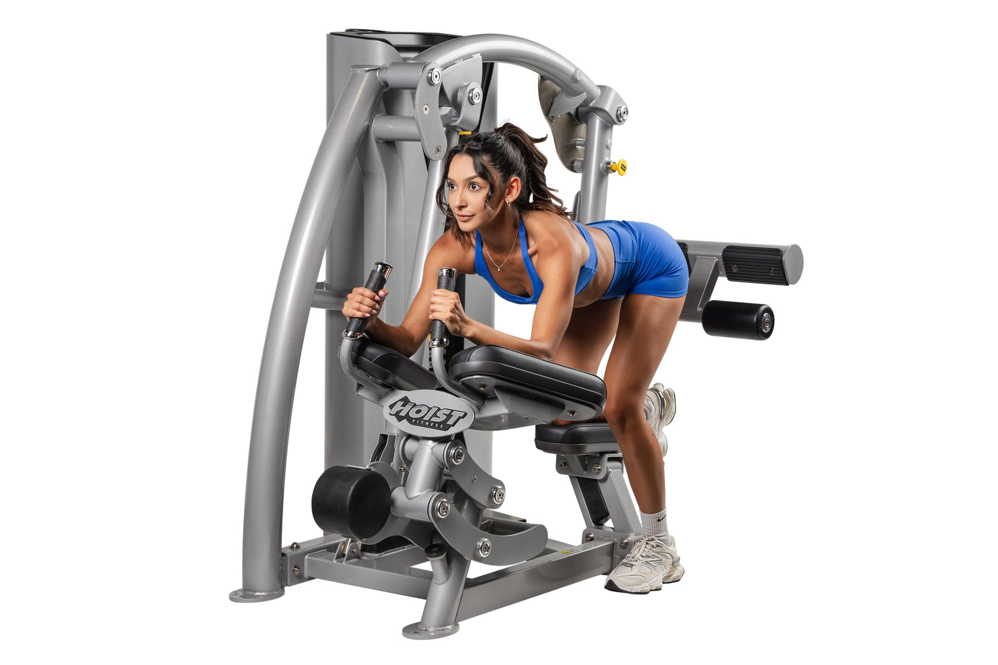 Woman in blue sports bra using silver and black Hoist ROC-IT Glute Master Machine with leg press attachment on white backgrou