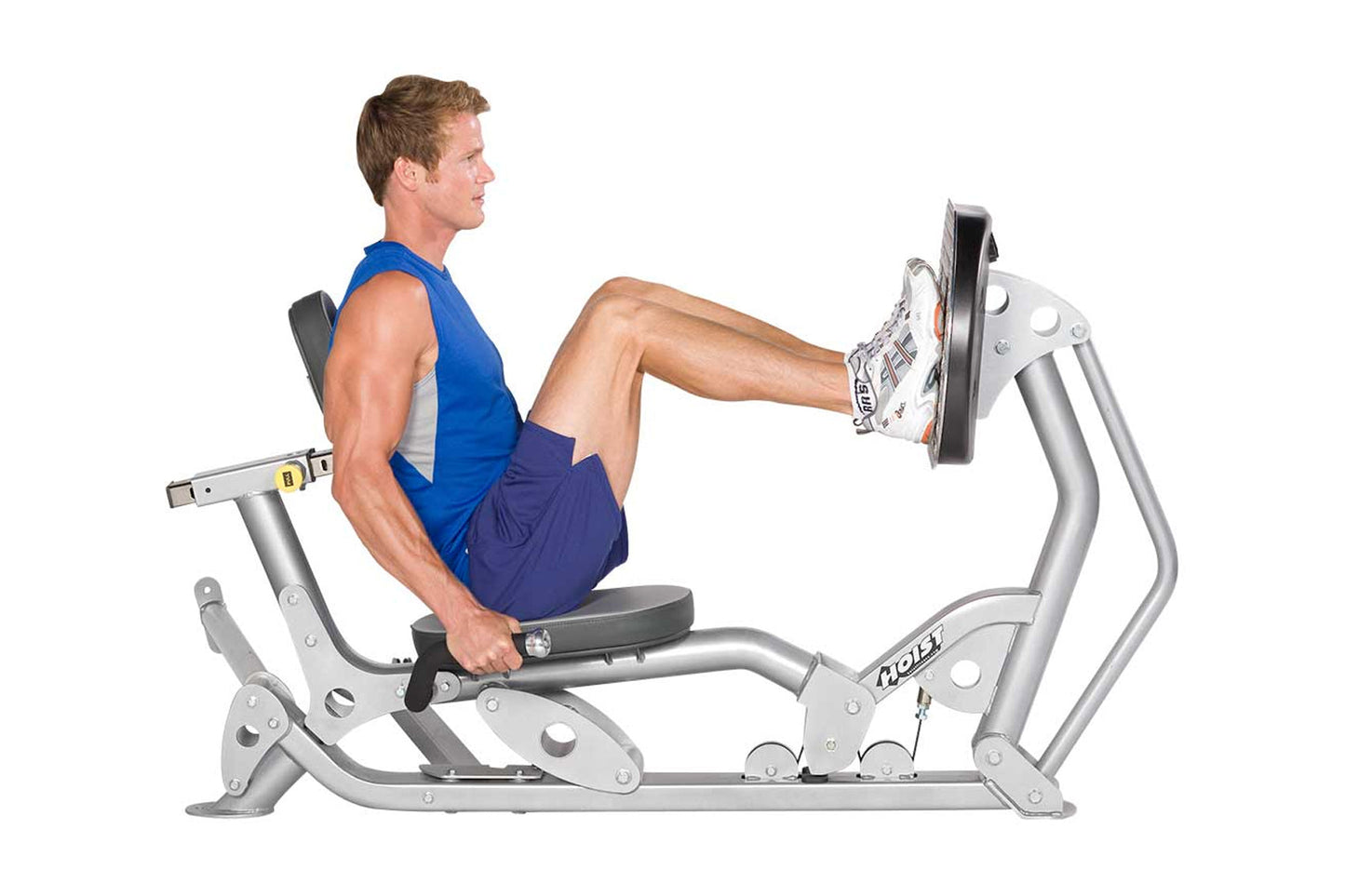 Man demonstrating leg press exercise on silver Hoist leg press machine with blue tank top, worn by model on white background