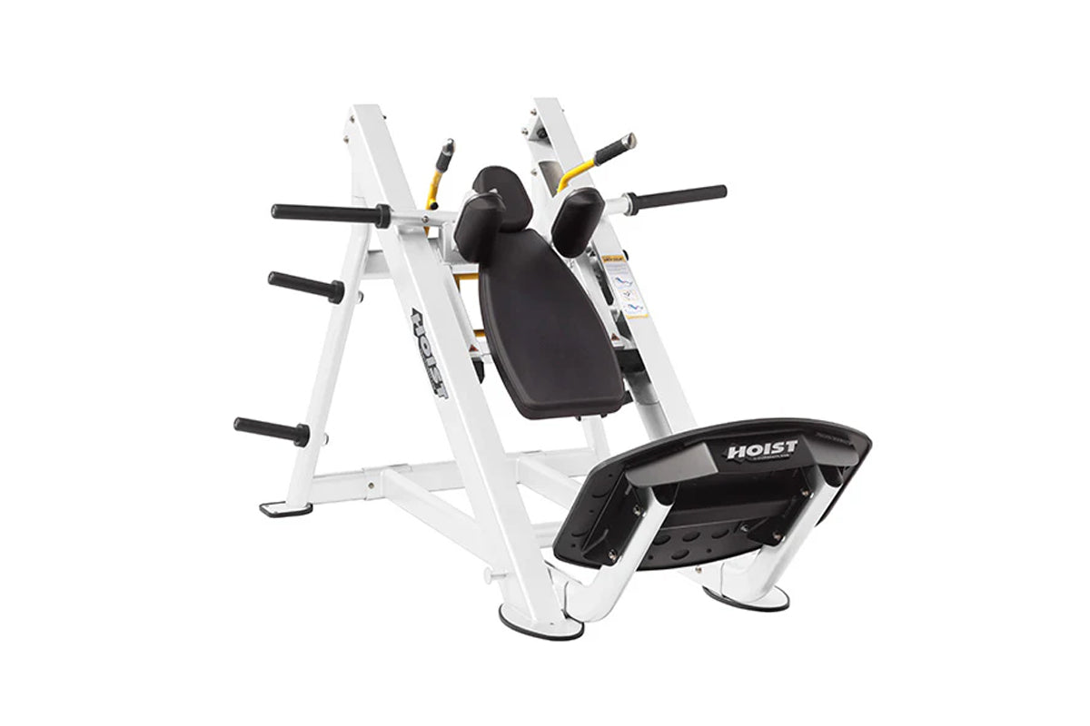 Hoist Hack Squat machine with white frame, black padded seat and shoulder pads, yellow accents, on white background