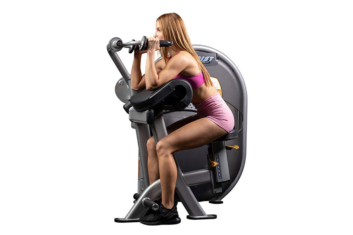 Woman in magenta sports bra using gray and black Hoist triceps extension machine on white background