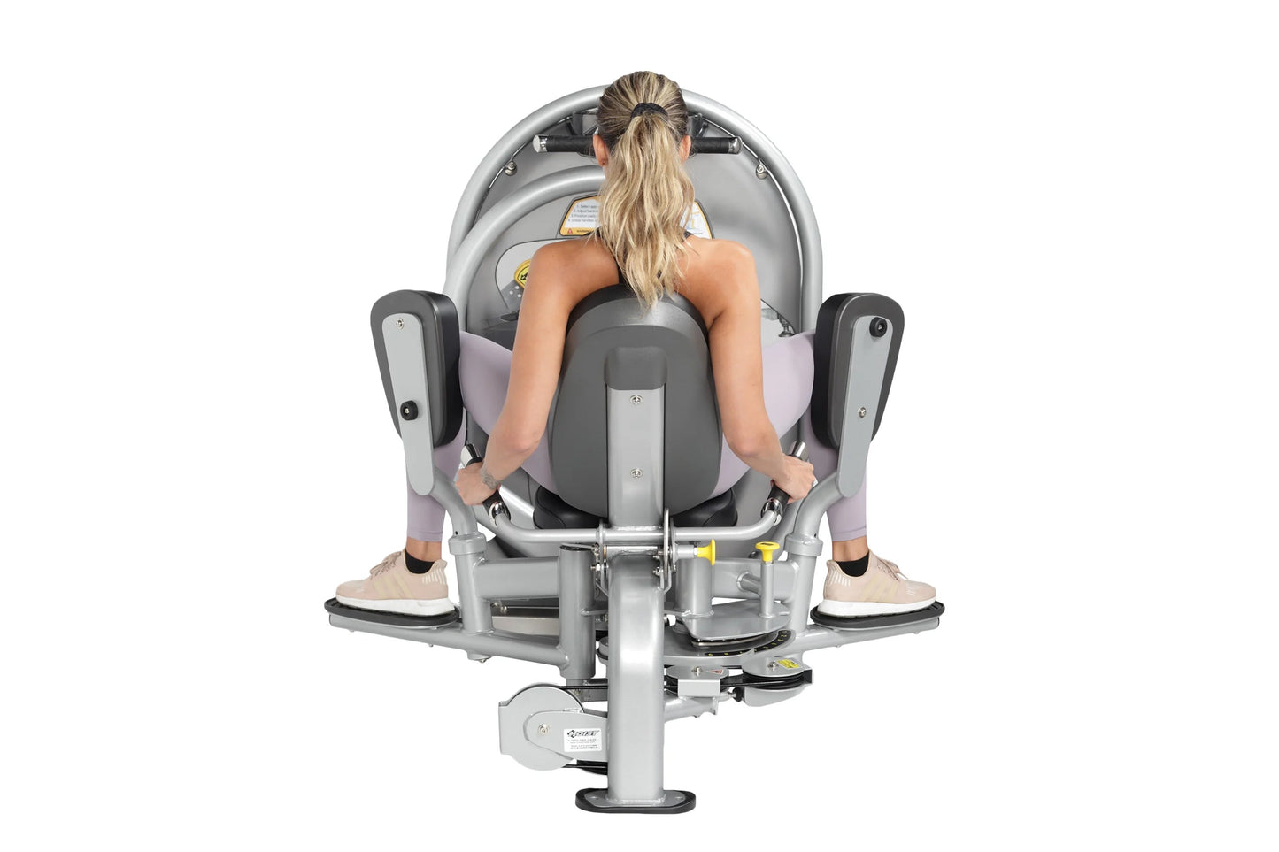 Woman using gray and lavender leg press machine with foot pedals, viewed from above, on white background