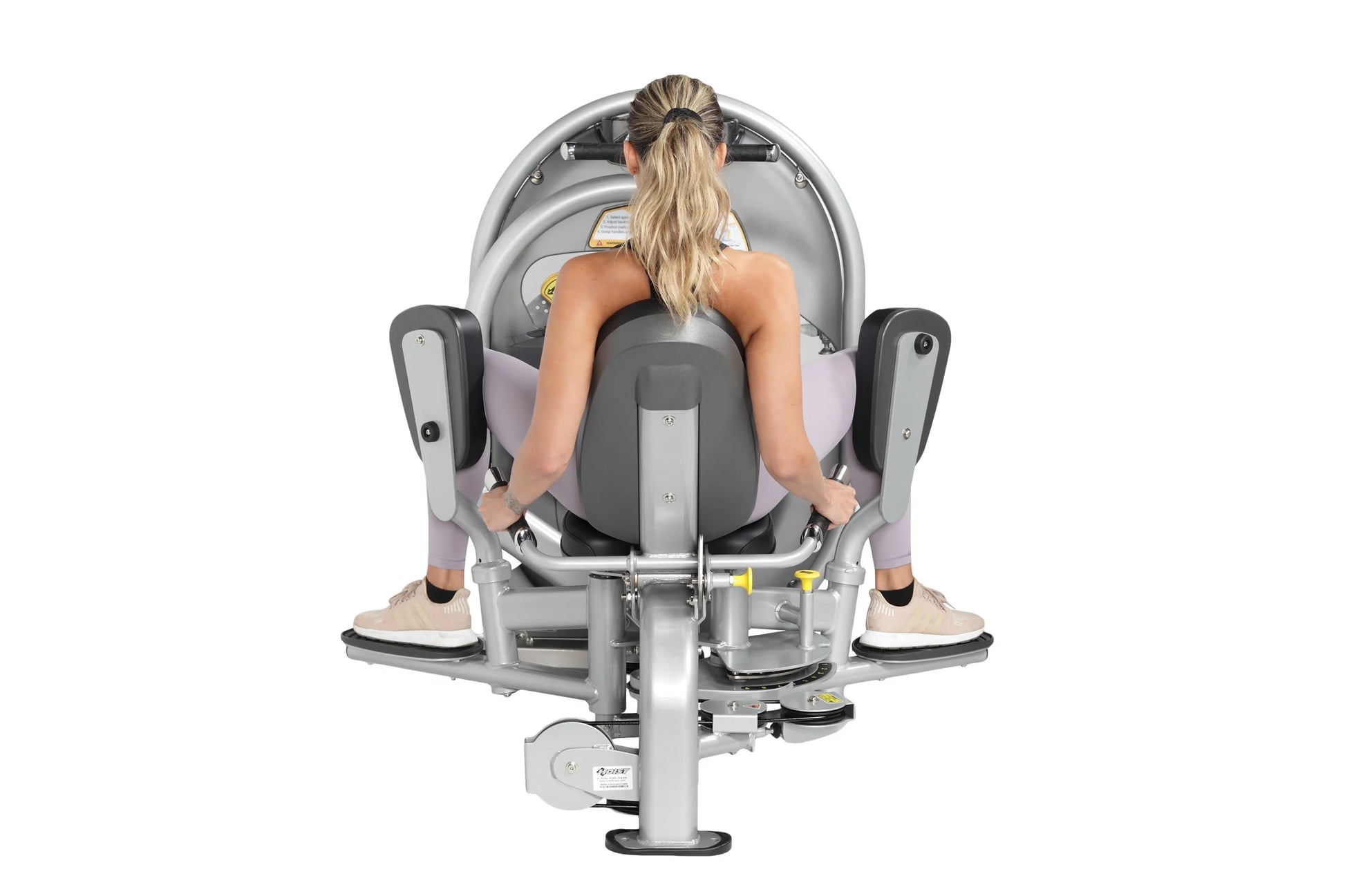Woman using gray and lavender leg press machine with foot pedals, viewed from above, on white background