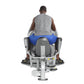 Man seated on gray and blue leg press machine viewed from behind, demonstrating proper thigh exercise form