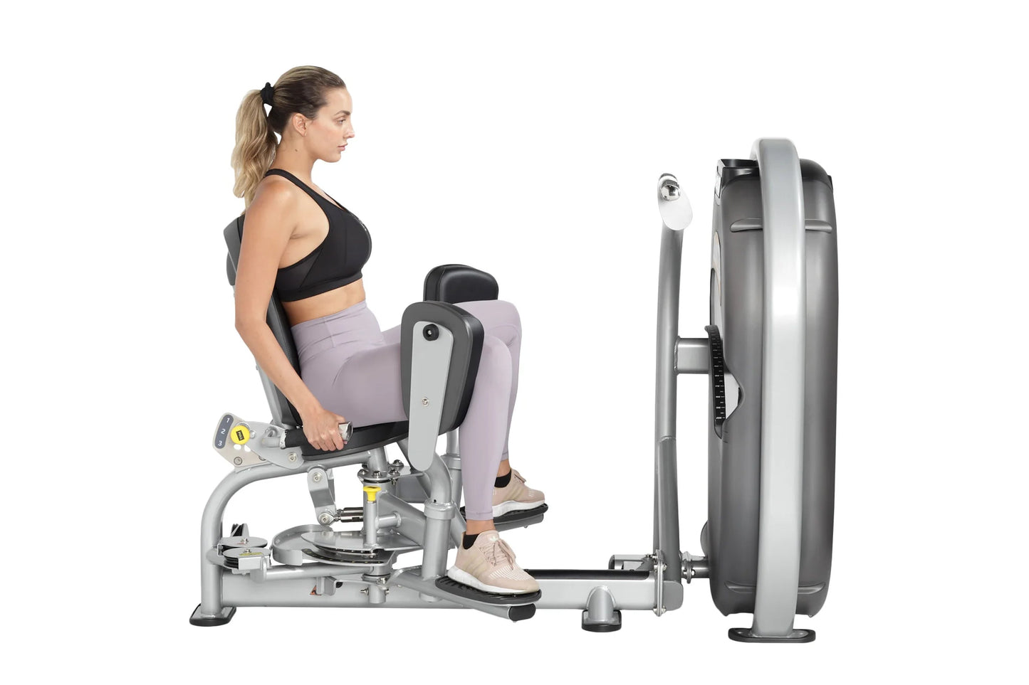 Woman using Hoist Club Line Inner/Outer Thigh exercise machine with gray and silver frame, black seat, and weight stack on wh