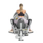 Woman using gray and black inner/outer thigh exercise machine, viewed from behind, on white background