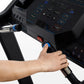 Hand on blue start button of black Horizon 5.0 AT treadmill with digital console display, worn by user
