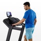 Man in blue shirt using black Horizon 5.0 AT treadmill with attached tablet display, shown in profile view