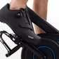 Black cycling shoe with perforated leather upper and dial closure system, worn on stationary bike pedal