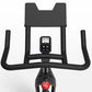 Black indoor exercise bike with curved handlebars, digital display console, and red brake button on white background