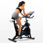 Woman using black and blue indoor stationary exercise bike with tablet holder, wearing black sports bra and gray shorts