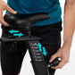Black stationary bike seat with adjustment arrows and numbered seatpost showing multiple height positions, worn by model in t