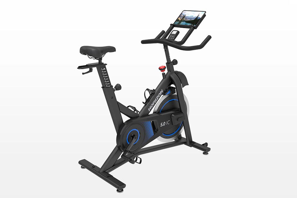 Black and blue indoor exercise bike with tablet holder and resistance dial, on white background