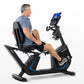 Middle-aged man in gray shirt and black shorts using black Horizon recumbent exercise bike with blue accents and blue display