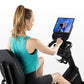 Woman in teal tank top using Horizon 5.0 R recumbent exercise bike with digital display screen on white background