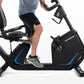 Horizon 5.0 R black recumbent exercise bike with blue accents, shown with male model seated and pedaling