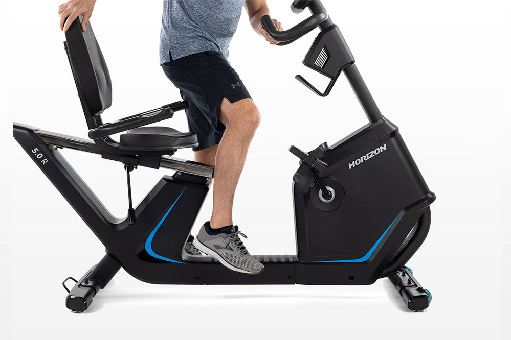 Horizon 5.0 R black recumbent exercise bike with blue accents, shown with male model seated and pedaling