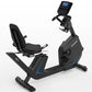 Black recumbent exercise bike with blue accent trim, blue digital display console, and padded seat with backrest on white bac