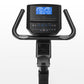 Black upright exercise bike with curved handlebar grips, digital console displaying blue screen metrics, and pedal base, on w