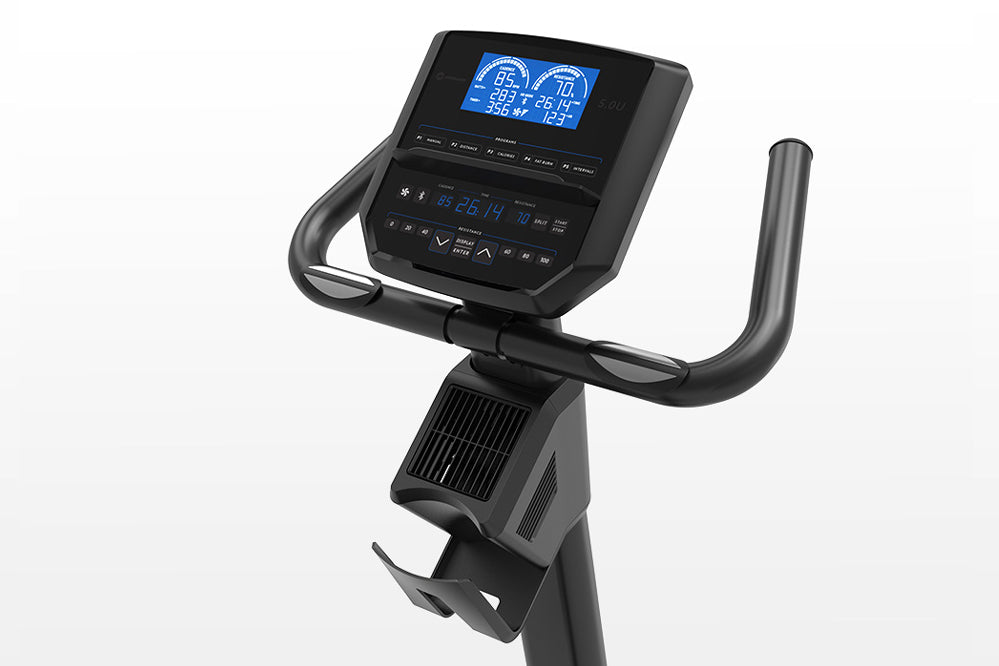 Black upright exercise bike with curved handlebars, foot pedals, and blue digital display console showing workout metrics