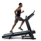 Man running on black Horizon 7.0 AT treadmill with blue accents, worn by model on white background