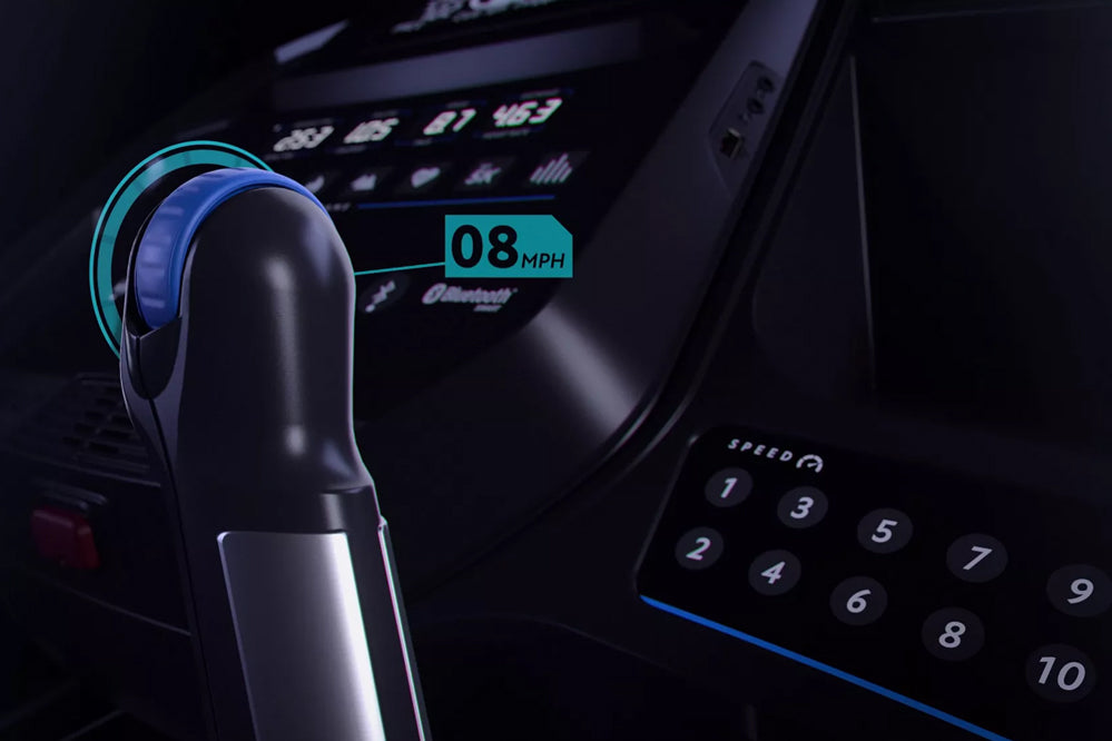 Black and blue wireless headphones on treadmill console displaying 08 MPH speed readout