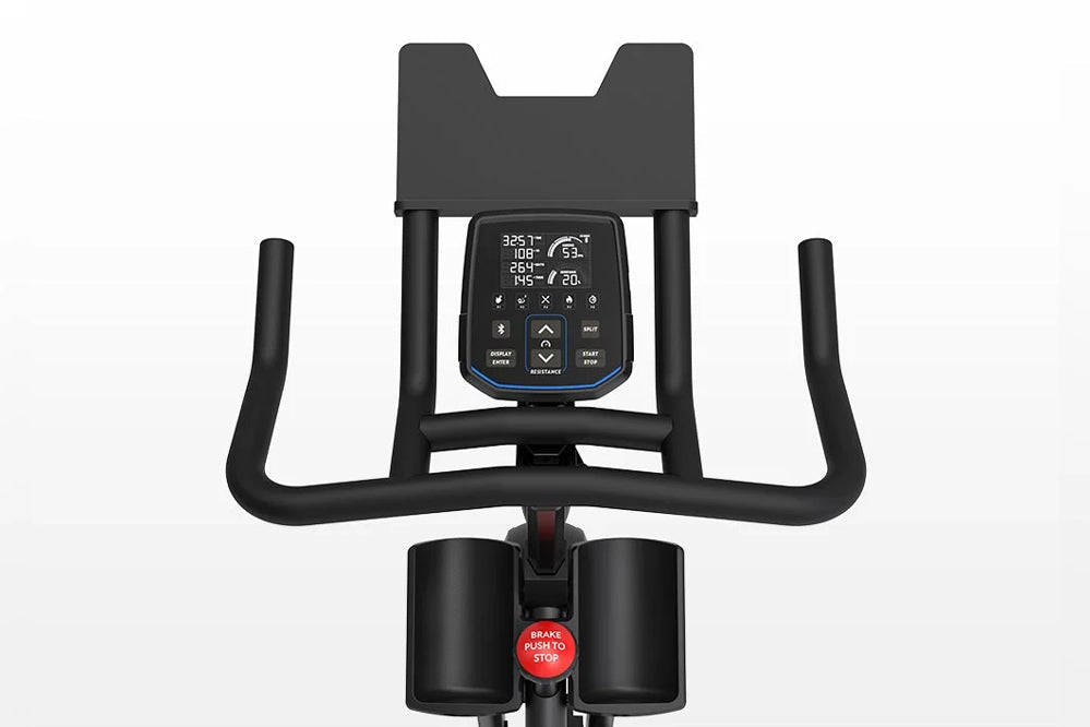 Horizon 7.0 IC black indoor stationary bike with digital console display, curved handlebars, and red brake button on white ba