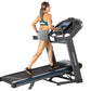 Woman in teal sports bra and gray shorts running on black Horizon treadmill with blue accents and digital display