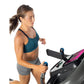 Woman wearing teal sports bra and gray shorts running on black and pink treadmill with blue handles