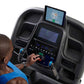 Person in blue shirt using black Horizon 7.8 AT treadmill with dual touchscreen displays and control console