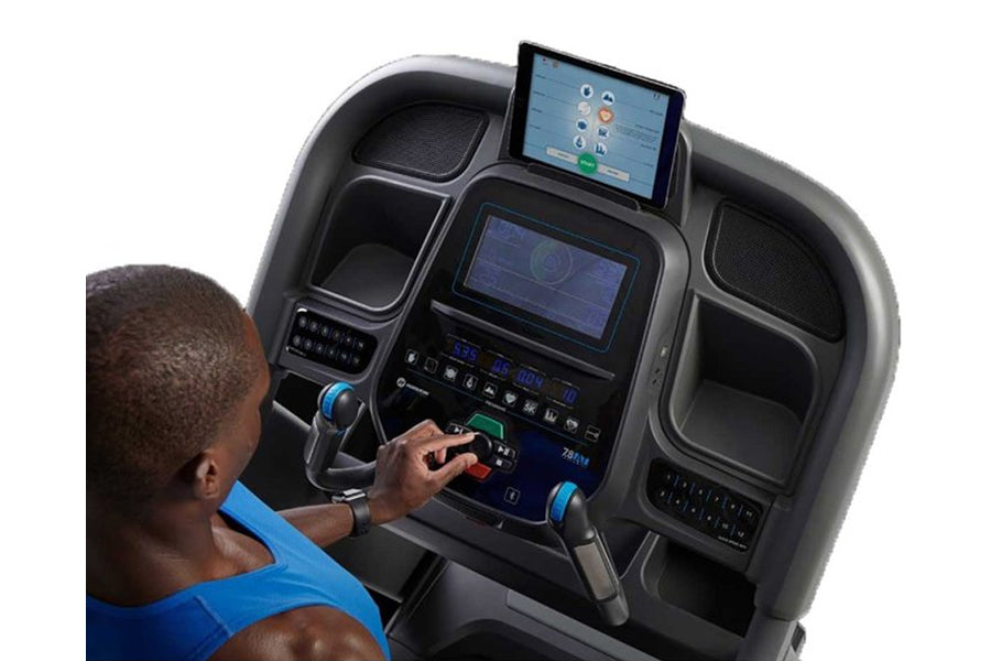 Person in blue shirt using black Horizon 7.8 AT treadmill with dual touchscreen displays and control console