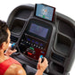 Man in red shirt using Horizon treadmill with dual digital display screens and control console