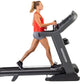 Woman in red tank top and gray shorts running on black Horizon 7.8 AT treadmill with digital console