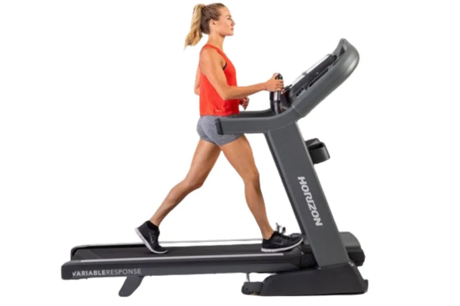 Woman in red tank top and gray shorts running on black Horizon 7.8 AT treadmill with digital console