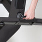 Black recumbent exercise bike with model's hand adjusting the resistance dial on horizontal handlebar