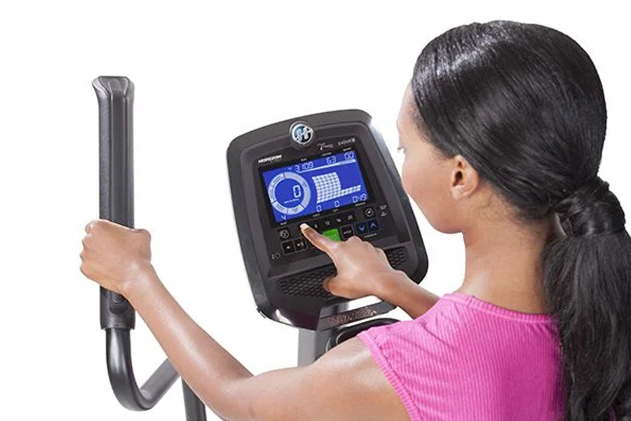 Woman in pink top using Horizon Evolve 5 elliptical with digital touchscreen console display