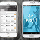 White iPhone and Samsung phone displaying Viafit workout app with fitness tracking data on wooden surface