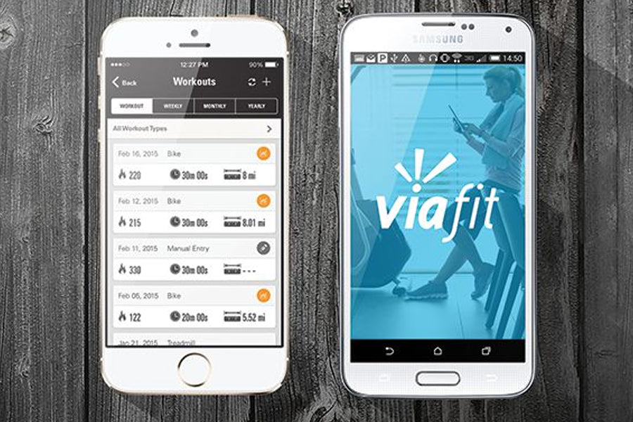 White iPhone and Samsung phone displaying Viafit workout app with fitness tracking data on wooden surface