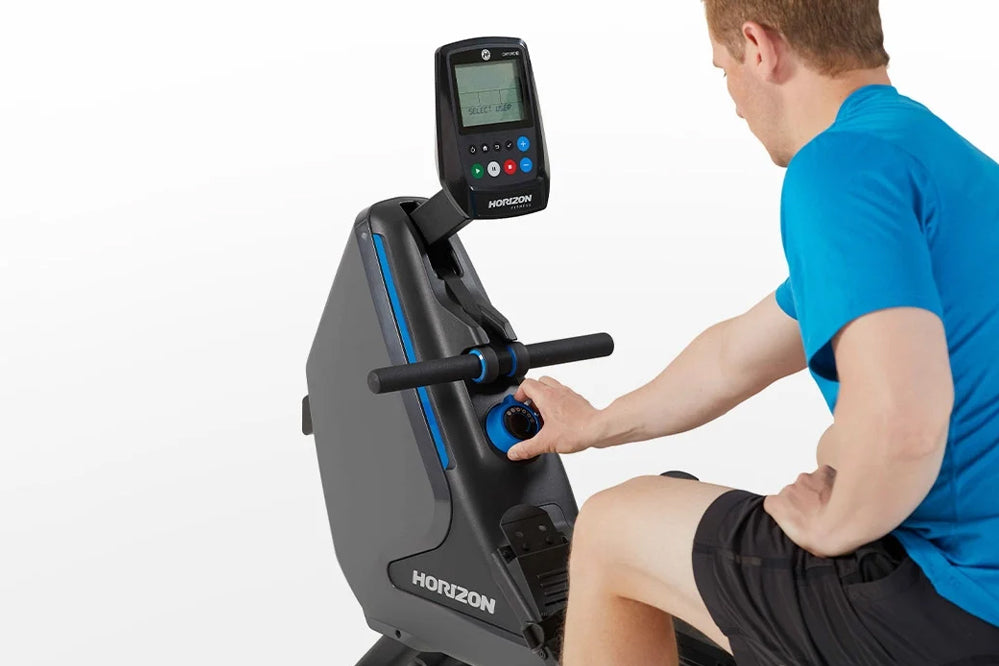 Man in blue shirt using gray and black Horizon Oxford 3 rowing machine with digital console display